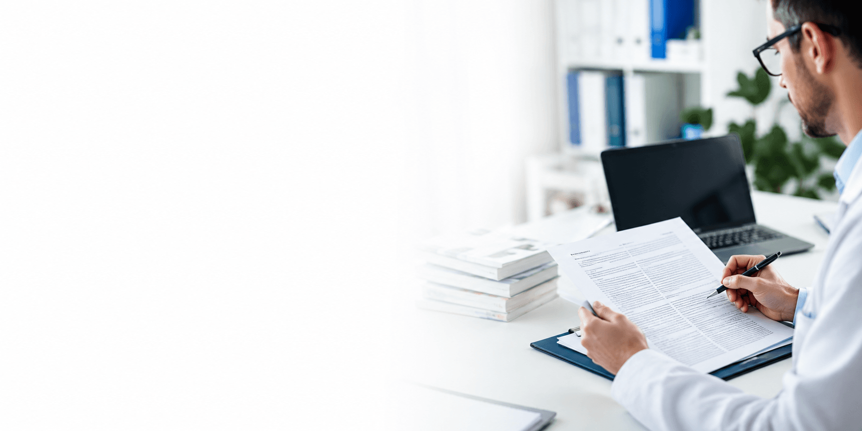 /open-access A researcher reviewing an open access manuscript alongside a stack of published journals.